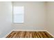 Empty bedroom showcasing neutral walls, wood-look floors, and a window with blinds at 1769 Dayton S St, St Petersburg, FL 33712