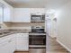 Modern kitchen features stainless steel appliances, white cabinets, and granite countertops at 1769 Dayton S St, St Petersburg, FL 33712