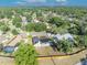Overhead shot of a vibrant neighborhood featuring a home, a fenced yard, and a swimming pool, all nestled among lush trees at 2601 Bridle Dr, Plant City, FL 33566