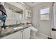Bathroom featuring a granite sink, marble floors, and modern toilet at 2601 Bridle Dr, Plant City, FL 33566