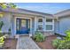 Inviting home entrance showcasing a blue front door, brick accents, and lush landscaping at 2601 Bridle Dr, Plant City, FL 33566