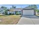 Charming home featuring a two-car garage, a lush front yard, and a welcoming entry door with walkway at 2601 Bridle Dr, Plant City, FL 33566