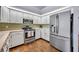 Well lit kitchen with stainless steel appliances, white cabinets, and hardwood style flooring at 2601 Bridle Dr, Plant City, FL 33566