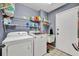 Functional laundry room featuring shelving, washer, dryer and cleaning supplies at 2601 Bridle Dr, Plant City, FL 33566