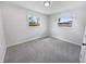 Bright bedroom with neutral decor, large windows, and plush gray carpeting at 4432 W Wallace Ave, Tampa, FL 33611