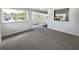 Open living room area featuring modern tile flooring and an open kitchen layout for seamless entertaining at 4432 W Wallace Ave, Tampa, FL 33611
