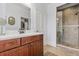Bathroom showcasing a wood vanity with a white countertop and a glass-enclosed shower with tiled walls at 8407 Interbay Blvd, Tampa, FL 33616