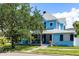 Charming two-story home with a welcoming front porch, manicured lawn, and mature landscaping, exuding curb appeal at 8407 Interbay Blvd, Tampa, FL 33616