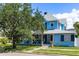Charming two-story home with a covered front porch, mature tree, and well-maintained lawn at 8407 Interbay Blvd, Tampa, FL 33616