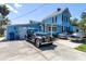 Charming blue two-story home with vintage cars in the driveway on a sunny day, creating a nostalgic ambiance at 8407 Interbay Blvd, Tampa, FL 33616