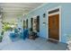 Inviting front porch with seating, ceiling fans, and a decorative lion statue by the wooden door at 8407 Interbay Blvd, Tampa, FL 33616