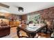 Spacious home office with a large desk, built-in storage, and library-themed wallpaper at 8407 Interbay Blvd, Tampa, FL 33616