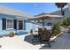 Cozy patio with an umbrella-covered table, chairs, and lovely landscaping, offering a relaxing outdoor space at 8407 Interbay Blvd, Tampa, FL 33616