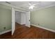 Bedroom with hardwood floors, neutral paint, with an open door to the ensuite bath at 11356 Callaway Pond Dr, Riverview, FL 33579
