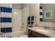 Bathroom with blue striped curtain, tiled shower, granite countertop and wood cabinet at 11456 Libby Rd, Spring Hill, FL 34609