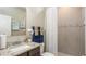Bathroom featuring granite countertop vanity and tiled shower with decorative accent strip at 11456 Libby Rd, Spring Hill, FL 34609
