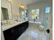 Bright bathroom features double vanity, garden tub, luxurious fixtures, and large window at 1409 S Moody Ave # 1, Tampa, FL 33629