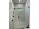 Brightly lit shower features white subway tile, hexagon tile floor, and seamless glass door at 1409 S Moody Ave # 1, Tampa, FL 33629