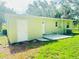 Rear exterior view of the home with a paved area, green lawn, and rear access door at 2731 Union S St, St Petersburg, FL 33712