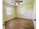 This bright bedroom has wood flooring, two windows, a ceiling fan, and a neutral color palette at 2731 Union S St, St Petersburg, FL 33712