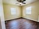 This bright bedroom has wood flooring, two windows, a ceiling fan, and a neutral color palette at 2731 Union S St, St Petersburg, FL 33712