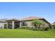 Inviting backyard features a covered patio, manicured lawn, and lush landscaping, creating a perfect outdoor oasis at 13084 Rinella St, Venice, FL 34293