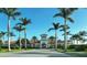 Elegant community clubhouse surrounded by lush palm trees under a clear blue sky at 13084 Rinella St, Venice, FL 34293