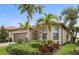 Charming single-story home with lush landscaping and swaying palm trees, offering a tranquil curb appeal at 13084 Rinella St, Venice, FL 34293