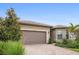 Inviting one-story home with a well-manicured lawn and a brick driveway, showcasing a modern design at 13084 Rinella St, Venice, FL 34293