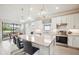Open-concept kitchen with a large island, pendant lighting, and stainless steel appliances, perfect for modern living at 13084 Rinella St, Venice, FL 34293