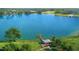 Scenic aerial view of a lake with a dock, gazebo, and green lawns at 14215 Suwannee Lake Dr, Dade City, FL 33525