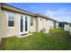 Backyard with green grass, generator, and French doors leading inside the home at 11402 Peckham Pl, Tampa, FL 33625