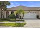 Charming single-story home with a two-car garage, lush landscaping, and beautiful palm trees in the front yard at 11402 Peckham Pl, Tampa, FL 33625