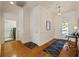 Well-lit hallway featuring hardwood floors, clean white walls, and views of the laundry room and front entrance at 11402 Peckham Pl, Tampa, FL 33625