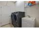 Functional laundry room with modern washer and dryer, storage cabinets, and a utility sink for added convenience at 11402 Peckham Pl, Tampa, FL 33625