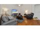 Cozy living room with plush sofa, recliner, television, and hardwood floors at 11402 Peckham Pl, Tampa, FL 33625