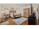 Spacious main bedroom featuring a wooden bed frame, neutral walls, hardwood floors, and natural light at 11402 Peckham Pl, Tampa, FL 33625