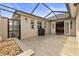 Large outdoor patio with brick pavers, covered lanai, black grill, and access to the kitchen at 11402 Peckham Pl, Tampa, FL 33625