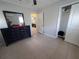 Neutral bedroom with closet, connecting door, and a dresser with mirror at 13 Euclid Dr, Plant City, FL 33563