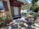 Exterior view showcasing the covered patio area, an exterior door and manicured landscaping at 13 Euclid Dr, Plant City, FL 33563
