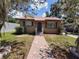 Charming single-story home featuring a brick walkway, lovely landscaping, and a durable metal roof at 13 Euclid Dr, Plant City, FL 33563