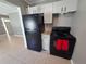 Functional kitchen with black appliances, white cabinetry, and tile flooring for easy maintenance at 13 Euclid Dr, Plant City, FL 33563