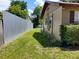 Side yard featuring green grass, partial metal fencing and an exterior view of the house at 13 Euclid Dr, Plant City, FL 33563