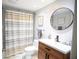 A stylish bathroom featuring new tile and fixtures with an attractive vanity and large round mirror at 4203 Fairway Run, Tampa, FL 33618