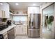 Bright kitchen featuring stainless steel refrigerator, white cabinetry and a view of the entry at 4203 Fairway Run, Tampa, FL 33618