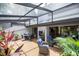 Relaxing outdoor patio area featuring covered pergola, wood floors, dining and seating areas, and lush greenery at 4203 Fairway Run, Tampa, FL 33618