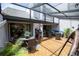 Inviting outdoor patio area featuring covered pergola, wood floors, dining and seating areas, and lush greenery at 4203 Fairway Run, Tampa, FL 33618
