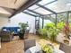 Relaxing enclosed patio with a glass roof, tile floors, lots of plants, and comfortable outdoor seating at 4203 Fairway Run, Tampa, FL 33618