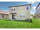 Well-maintained backyard with lush green grass, a sliding glass door, and a partial view of the neighboring home at 1844 Brekey Way, Zephyrhills, FL 33541