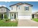 Charming two-story home boasts a well-manicured lawn, two-car garage and welcoming front porch at 1844 Brekey Way, Zephyrhills, FL 33541